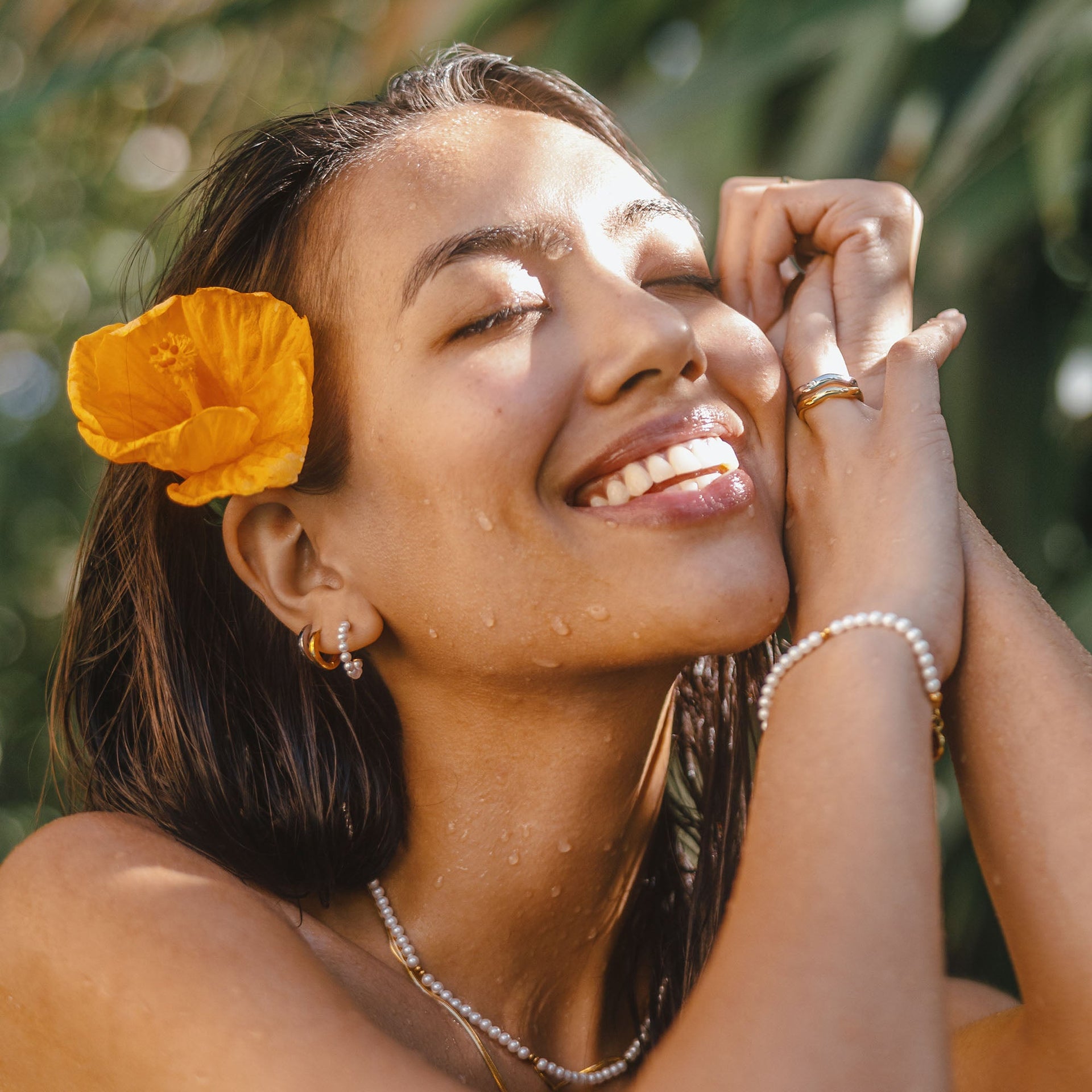 Feminine PURELEI Perlenkette und Ohrringe, strahlend im Sonnenlicht, mit tropischem Flair.