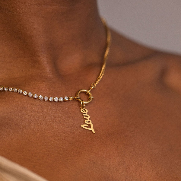 PURELEI Love Charm Anhänger aus 18K Gold, filigran, elegant am Hals getragen, feminine Leichtigkeit und Liebe.