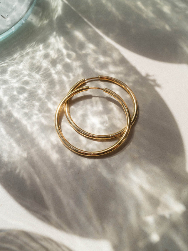 Nickelfreie Silbercreolen auf sanftem Hintergrund mit Lichtspiel, PURELEI inspiriert.