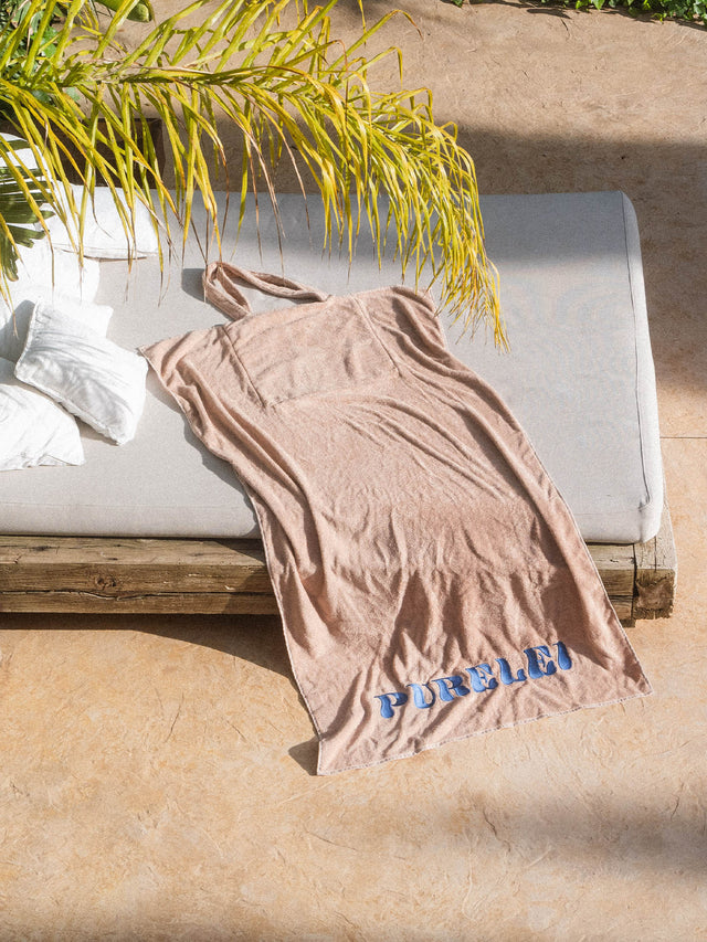 Blue Paradise Badetuch aus beiger Baumwolle mit blauer Stickerei, lässig auf Liege am Pool von PURELEI