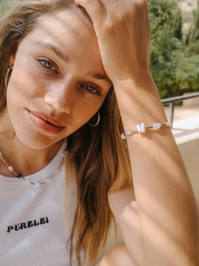 Zartes Armband aus Muscheln und Glas, getragen von einer Frau mit natürlichem Look, PURELEI.