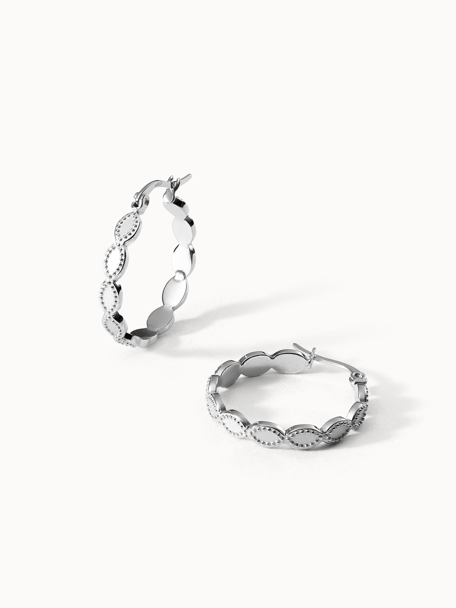 Silberne Creolen mit geschwungenem Design von PURELEI, elegant und modern.