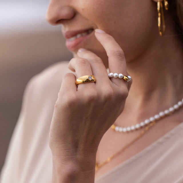 Elastischer Anxiety Lovely Ring mit Muschelperlen und Herz, vergoldet, getragen am Finger, pure feminine Eleganz von PURELEI.