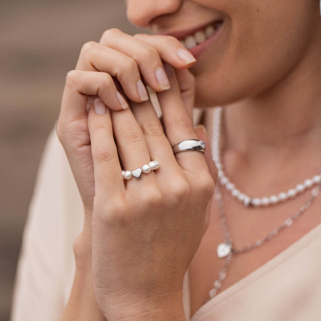 PURELEI Anxiety Lovely Ring aus Silber mit Muschelperlen und Herz, elegant getragen für feminine Leichtigkeit.