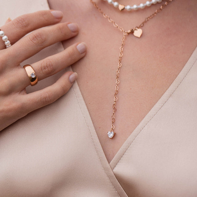 Roségoldene Herz-Kette von PURELEI, elegant und feminin, getragen auf sanftem Stoff.