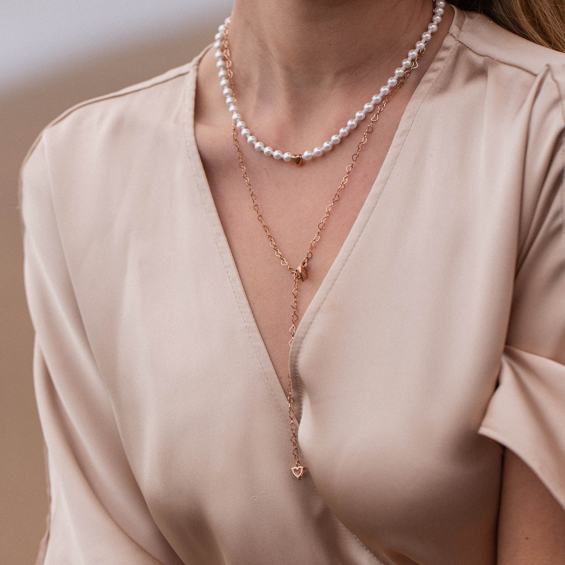 Zarte PURELEI Kette mit weißen Perlen und roségoldener Herzanhänger, elegant und feminin.
