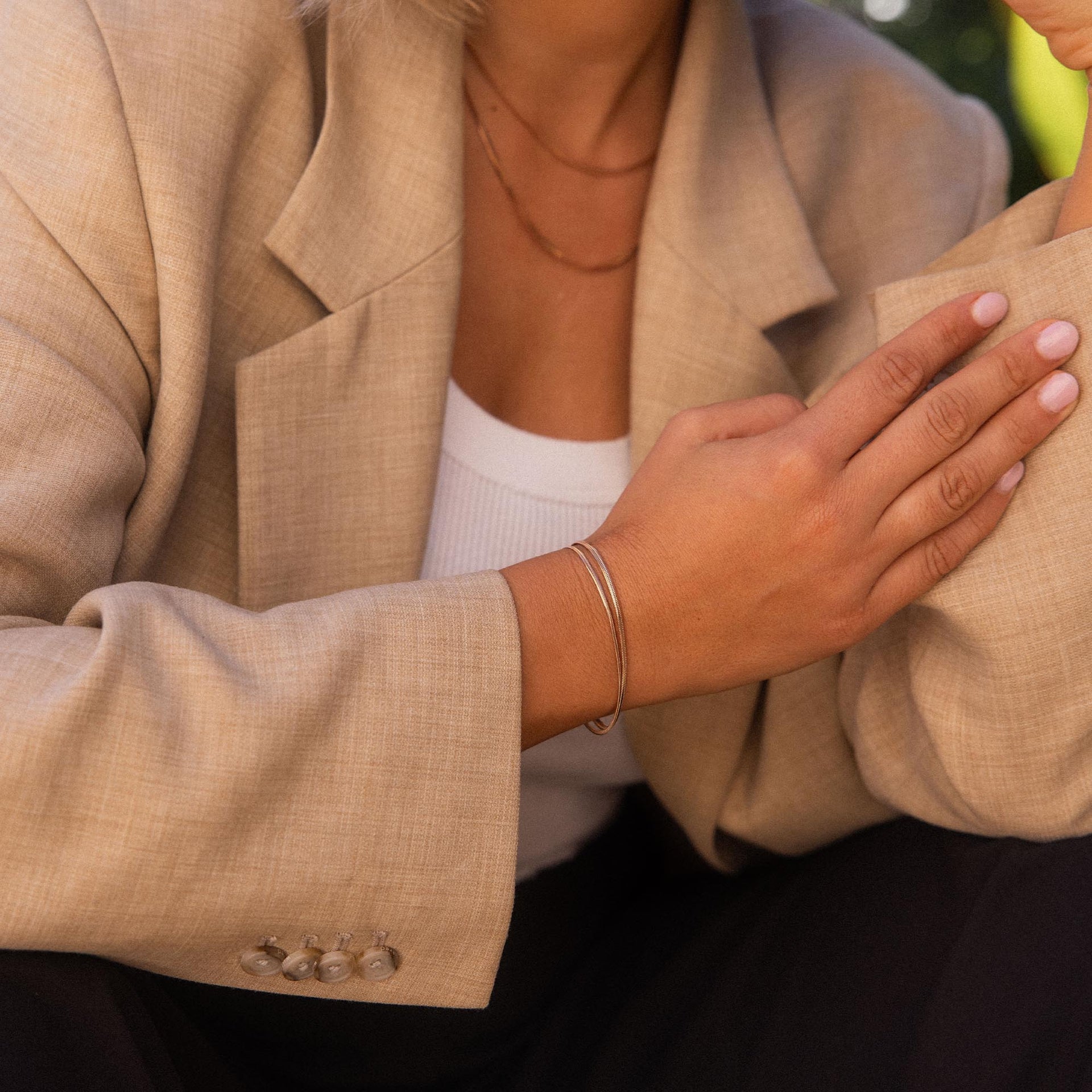 Silbernes Armband von PURELEI am Handgelenk, elegant und modern, getragen mit Blazer.