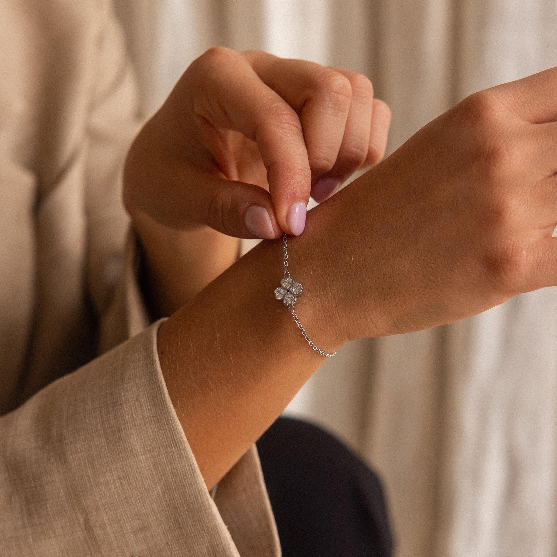 Silbernes Armband mit floralen Anhänger, getragen am Handgelenk, PURELEI-Design.