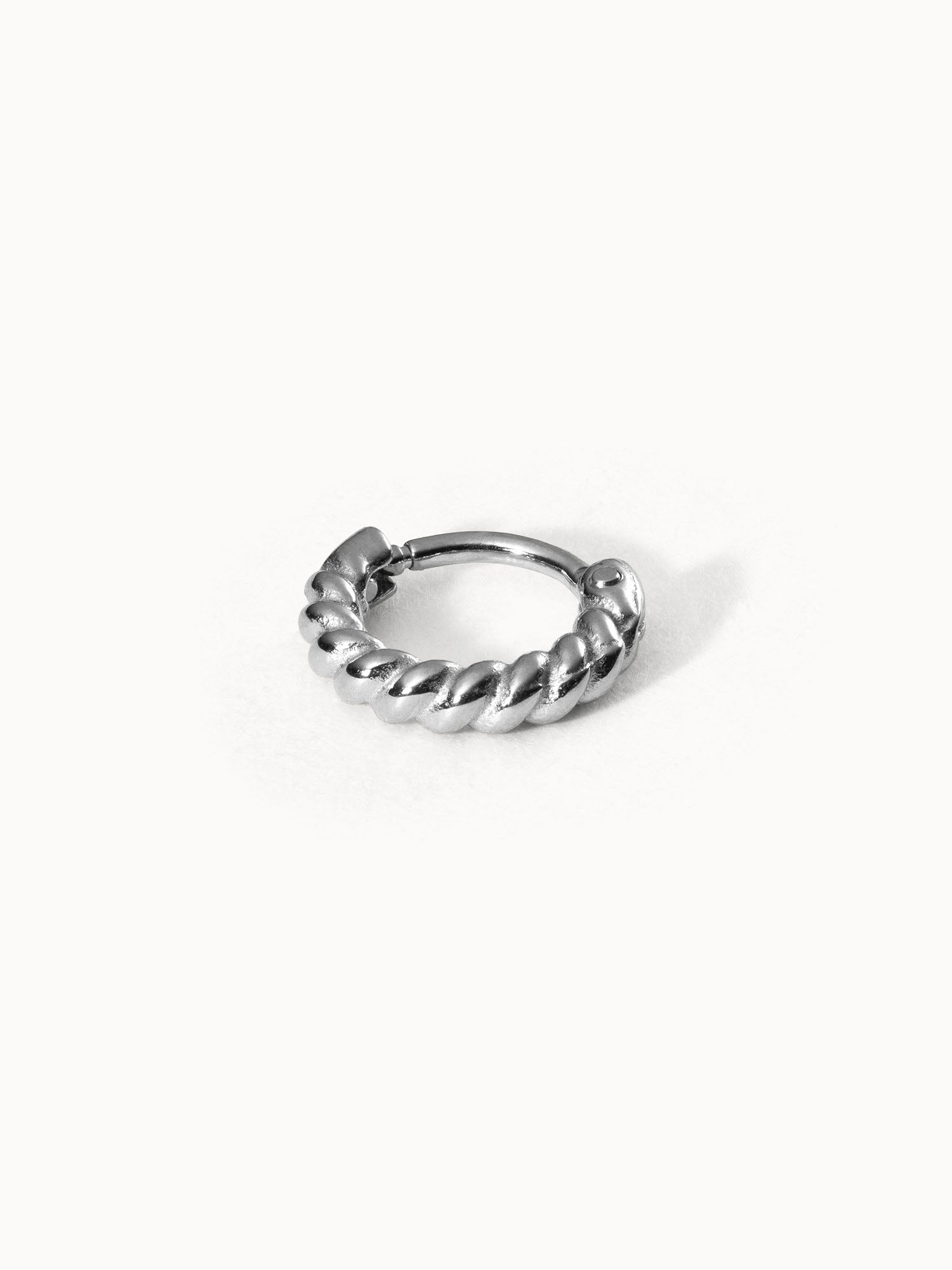 Silberner, gedrehter Ring von PURELEI auf weißem Hintergrund, elegant und modern.