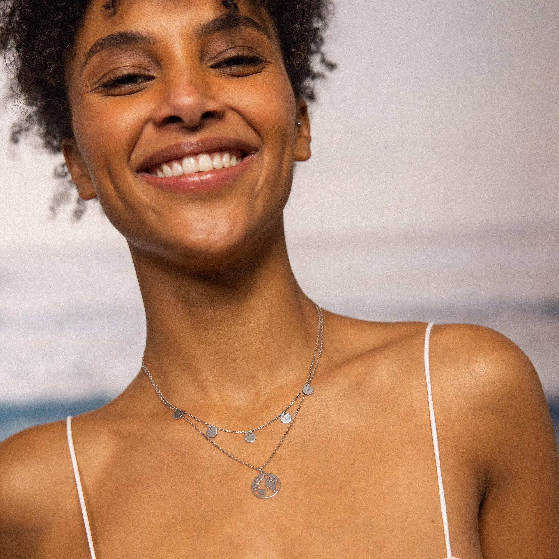 Silberne Kette mit Weltanhänger und kleinen Plättchen, PURELEI, strahlt Lebensfreude aus.