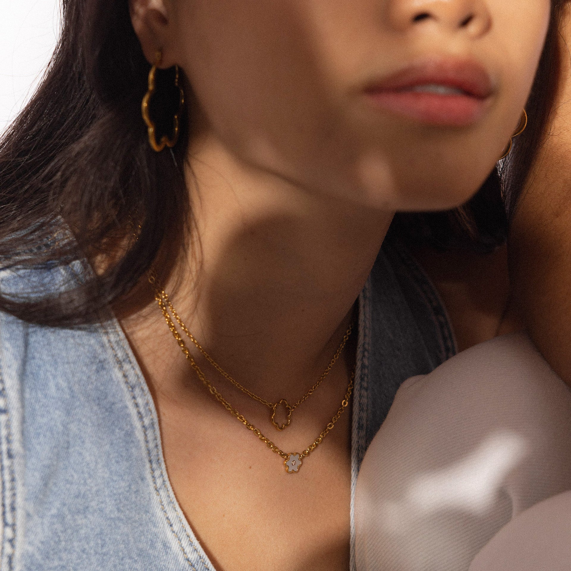 PURELEI Bloom Kette aus goldfarbenem Edelstahl mit filigranem Blütenanhänger, elegant geschichtet getragen.