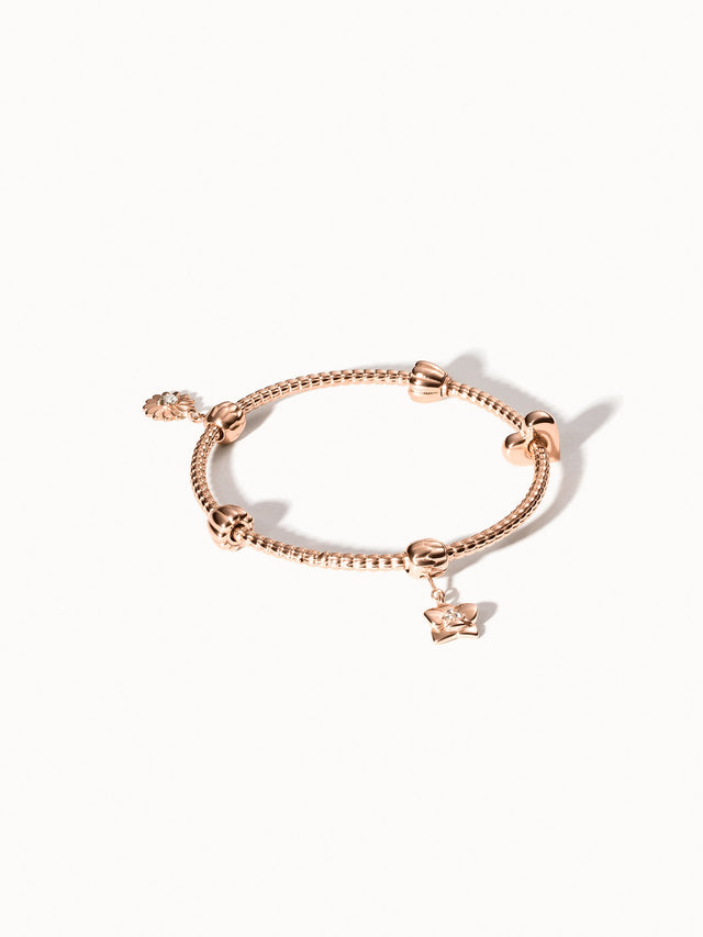 PURELEI Lei Charm Armreif Roségold mit zwei Stopper-Charms, detailreiches Blumendesign, elegant auf hellem Hintergrund