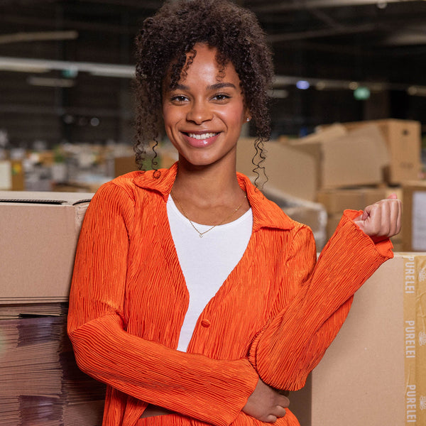 Strahlendes, oranges Oberteil mit Struktur, getragen von einer lächelnden Frau, PURELEI-Feeling.