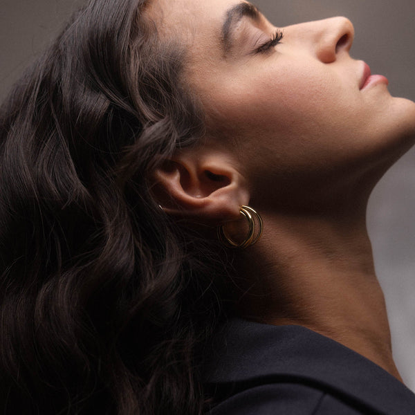 Roségoldene Creolen von PURELEI, elegant und feminin, getragen mit sanften Wellen im Haar.