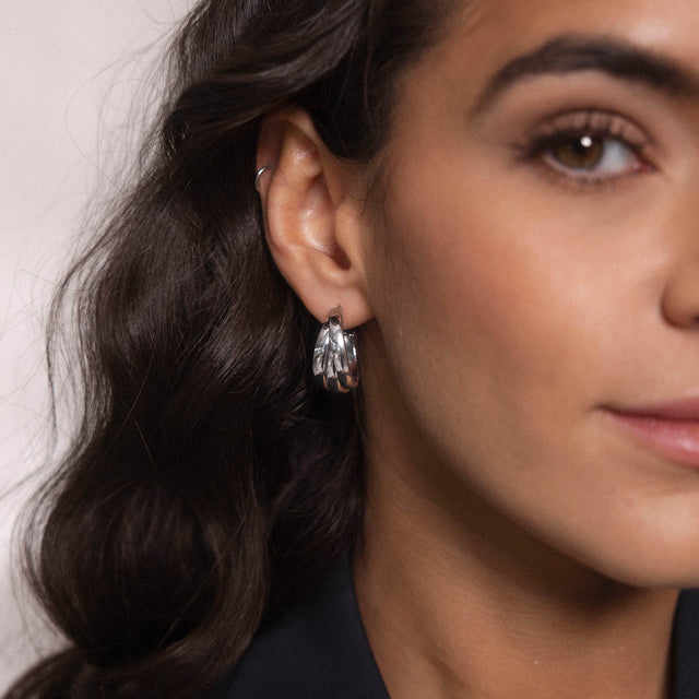 Silberne Creolen mit elegantem Design, getragen von einer Frau, PURELEI.