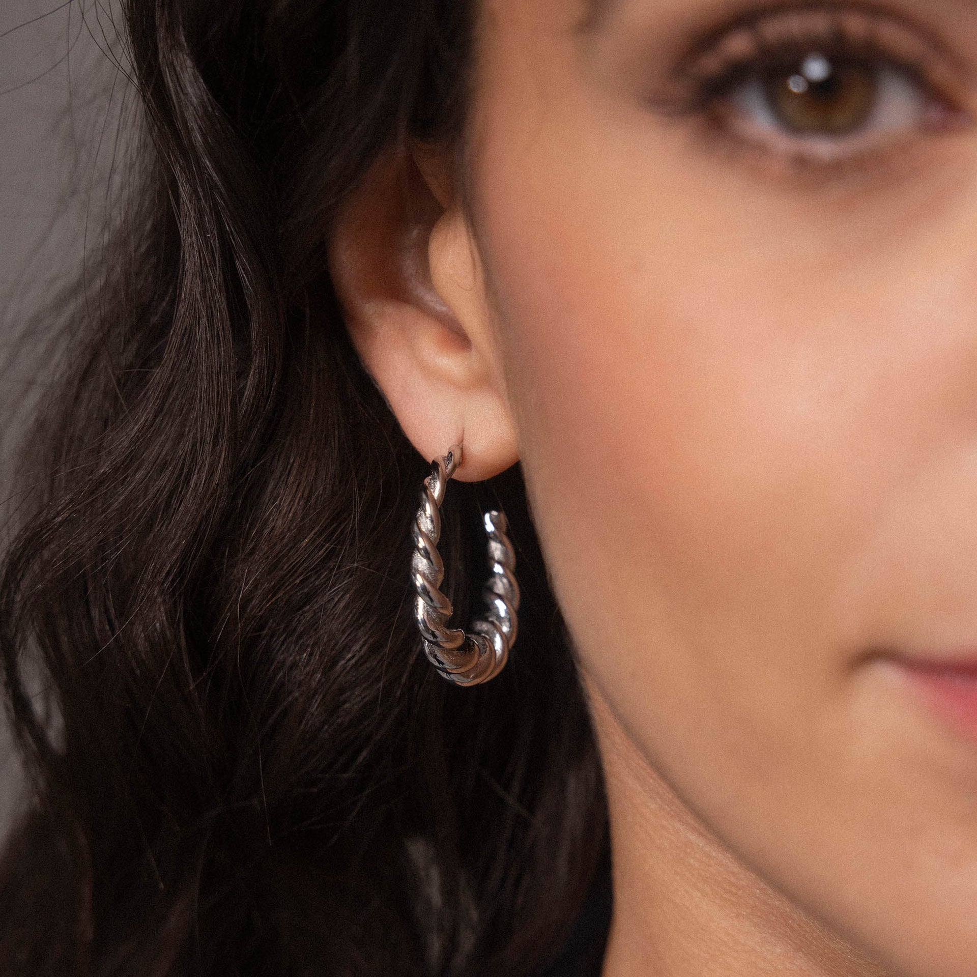 Roségoldene Creolen mit gedrehter Struktur, getragen von einer Frau, PURELEI.