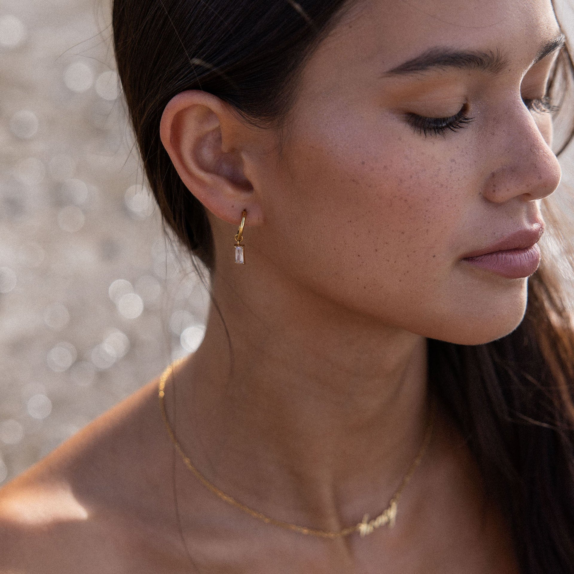 PURELEI Shine Bright Ohrringe aus 18K Gold mit glänzendem Zirkonia, elegant und zeitlos am Ohr getragen.