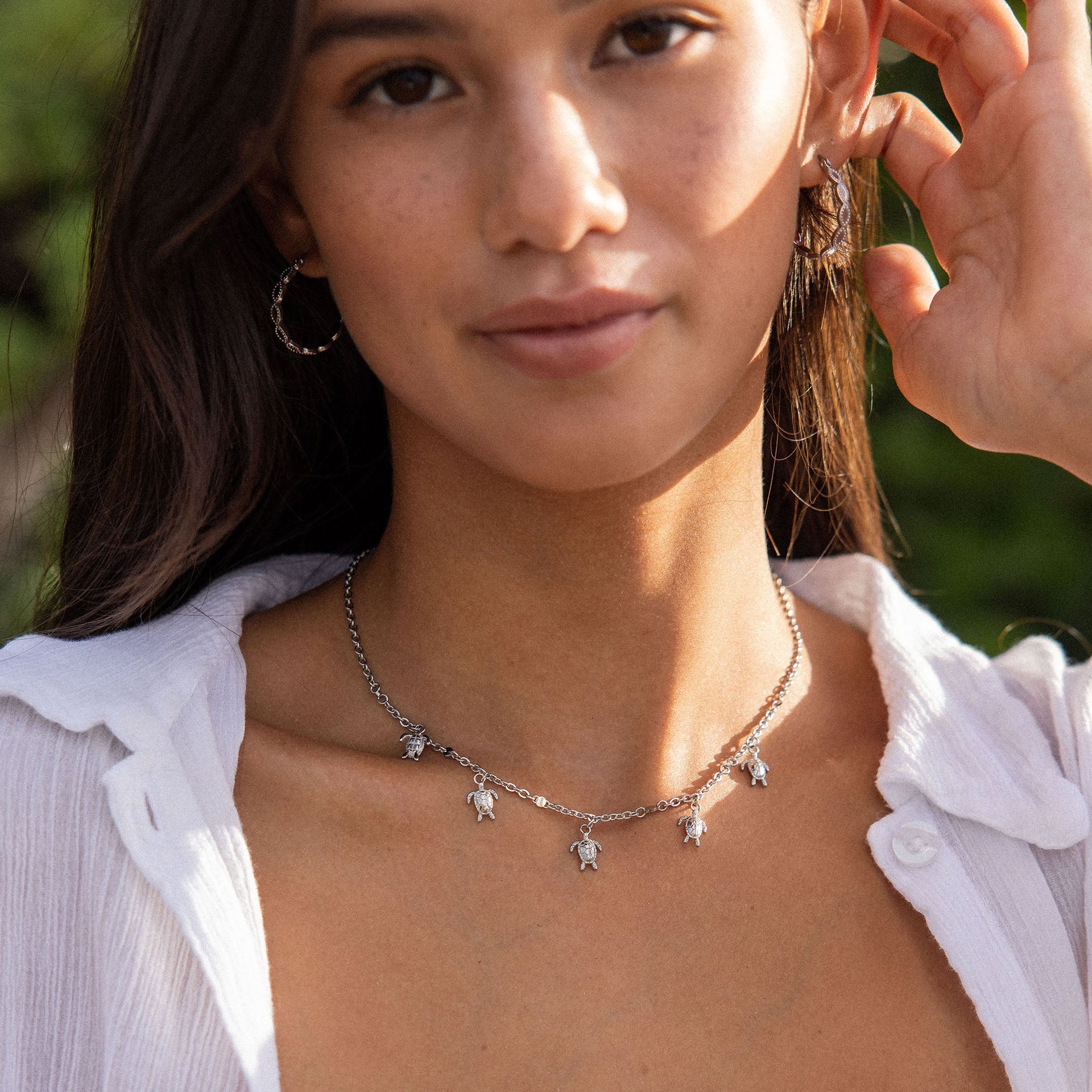 Silberne Kette mit Schildkröten-Anhängern, getragen von einer Frau, PURELEI.