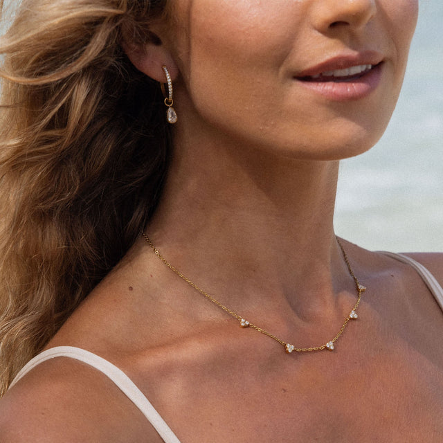 PURELEI Amicizia Kette mit goldener Edelstahlkette und Zirkonia-Steinen, elegant am Dekolleté getragen