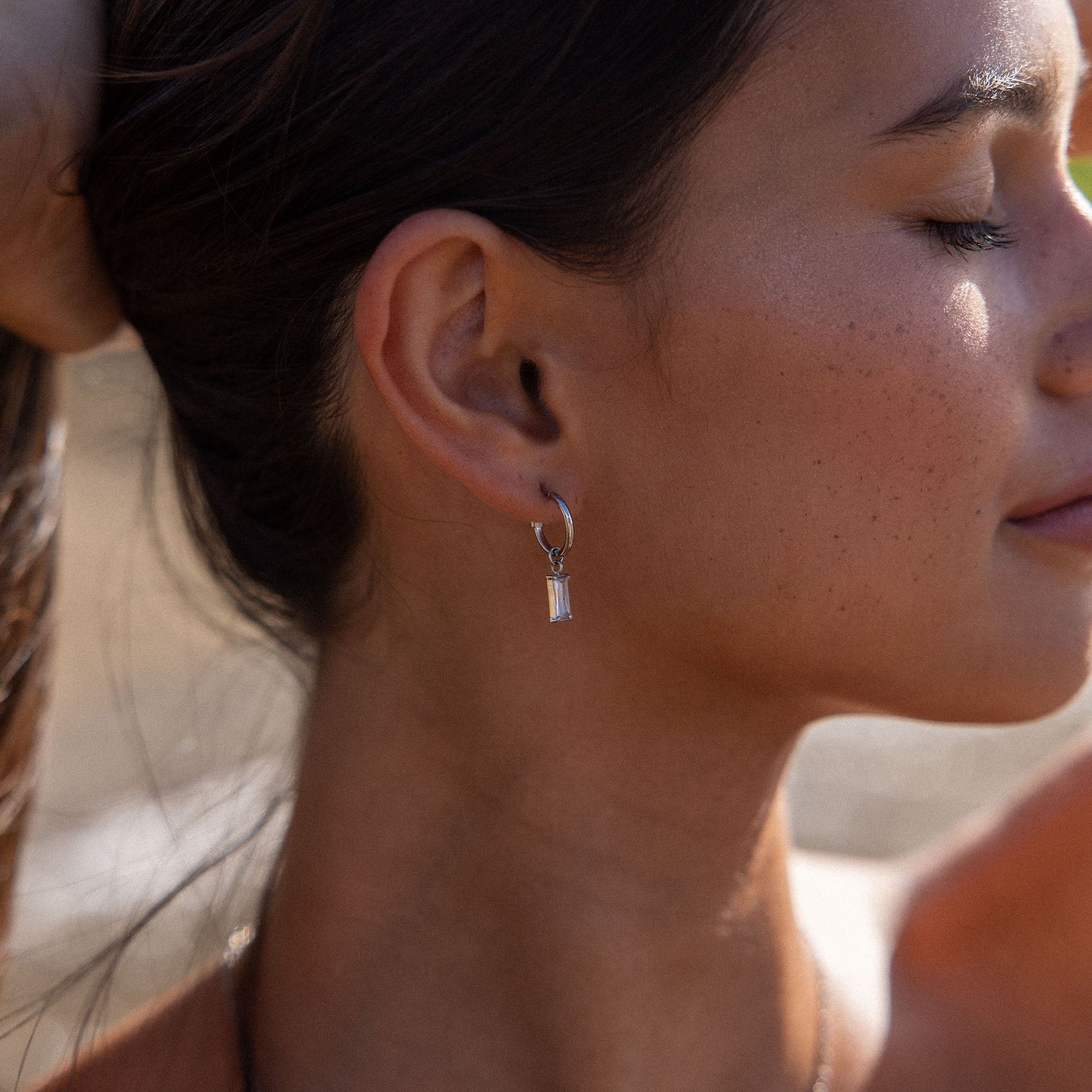 PURELEI Shine Bright Ohrringe in Silber mit funkelndem Zirkonia-Anhänger, elegant und feminin getragen.