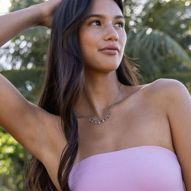 PURELEI Shine Bright Kette aus silbernem Edelstahl mit funkelnden Zirkonia, getragen in natürlichem Beach-Look.