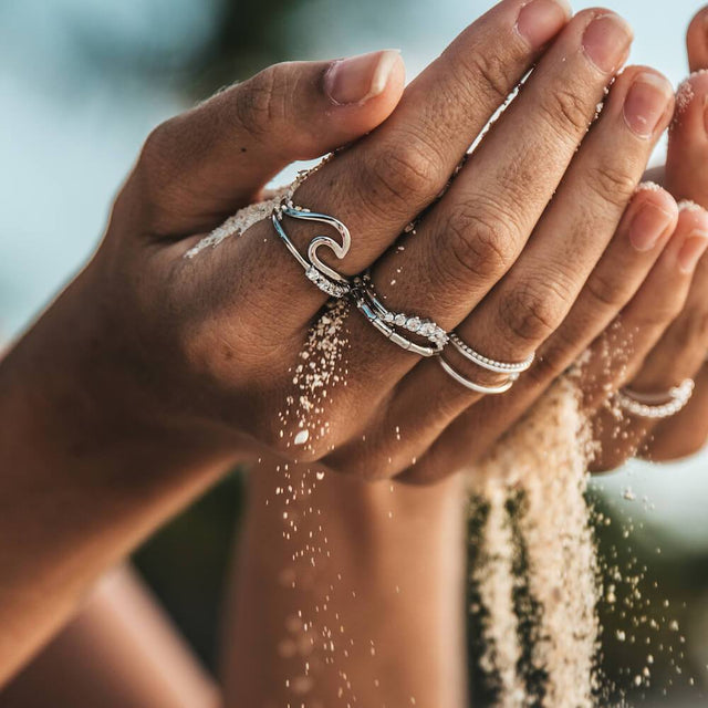 Malihini Ring von PURELEI in Silber mit V-Design, nickelfrei, getragen im Sand, moderne Insel-Ästhetik.