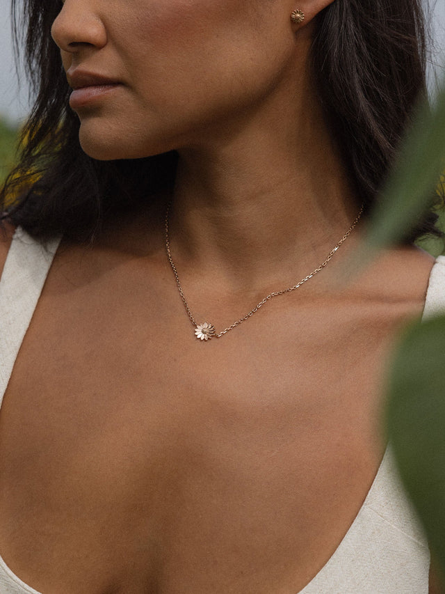 Roségoldene Kette mit Blütenanhänger, getragen in natürlicher Umgebung – PURELEI.