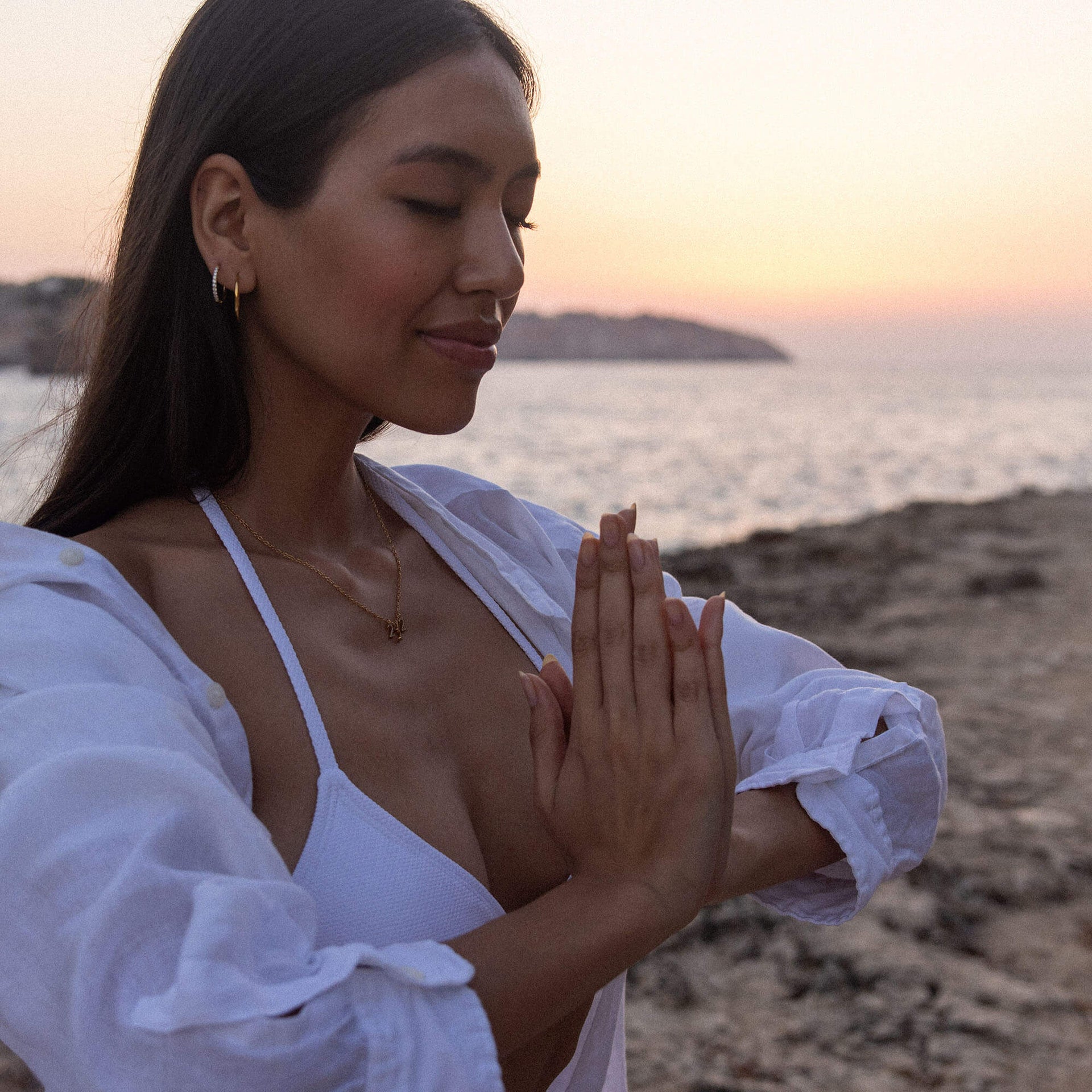 Feine 222 Kette aus vergoldetem Edelstahl mit Zirkonia getragen bei Sonnenuntergang am Meer