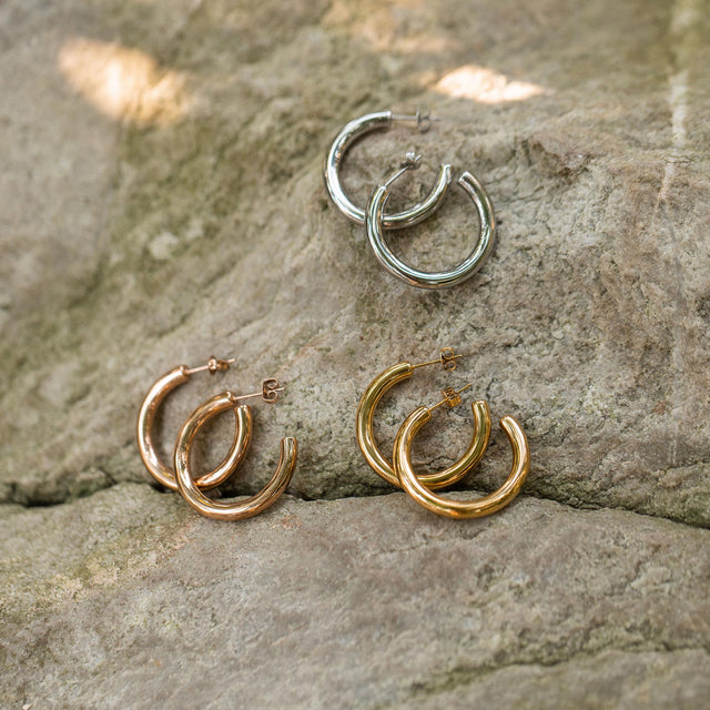 PURELEI Kumu O Creolen in Gold, Silber und Roségold auf Naturstein, clean & elegant präsentiert.