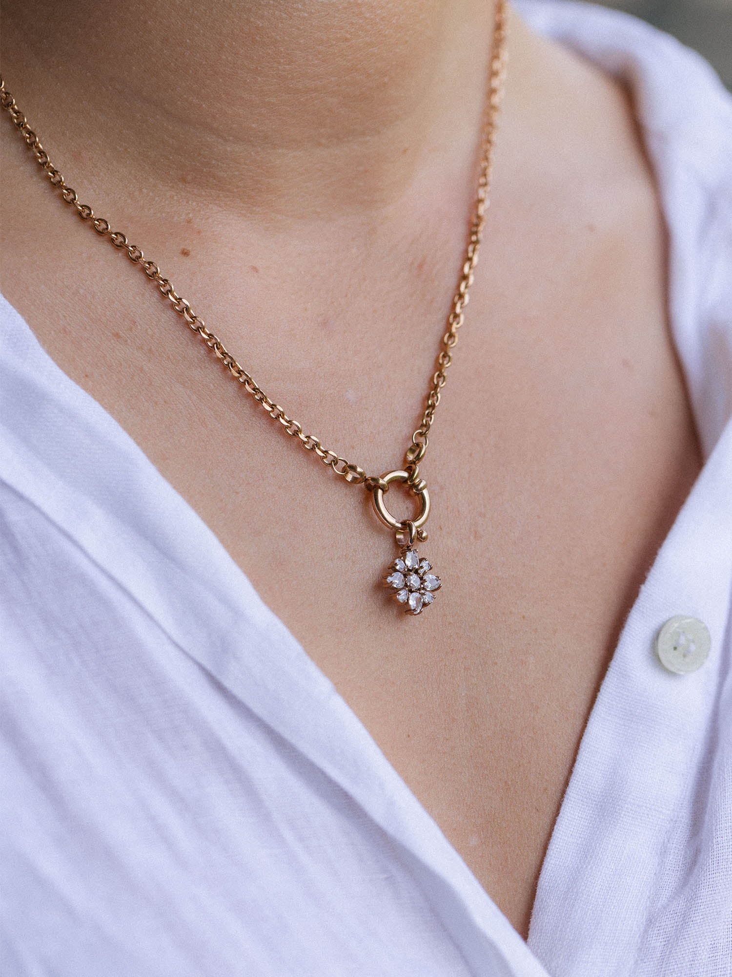 PURELEI Blossom Charm Halskette in Roségold mit funkelndem Blütenanhänger auf hellem Hautteint, elegant und feminin