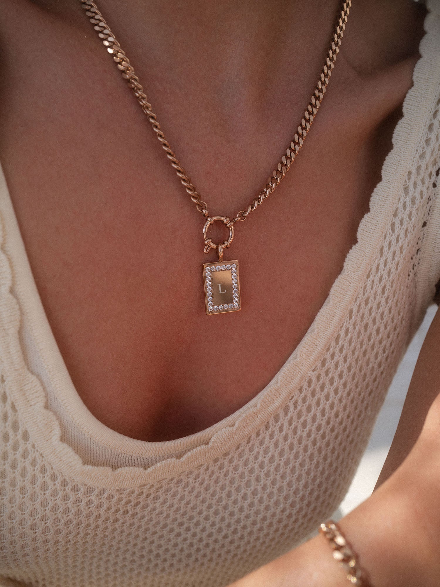 PURELEI Glimmer Charm aus 14K vergoldetem Edelstahl mit Zirkonia, elegant am Dekolleté getragen.