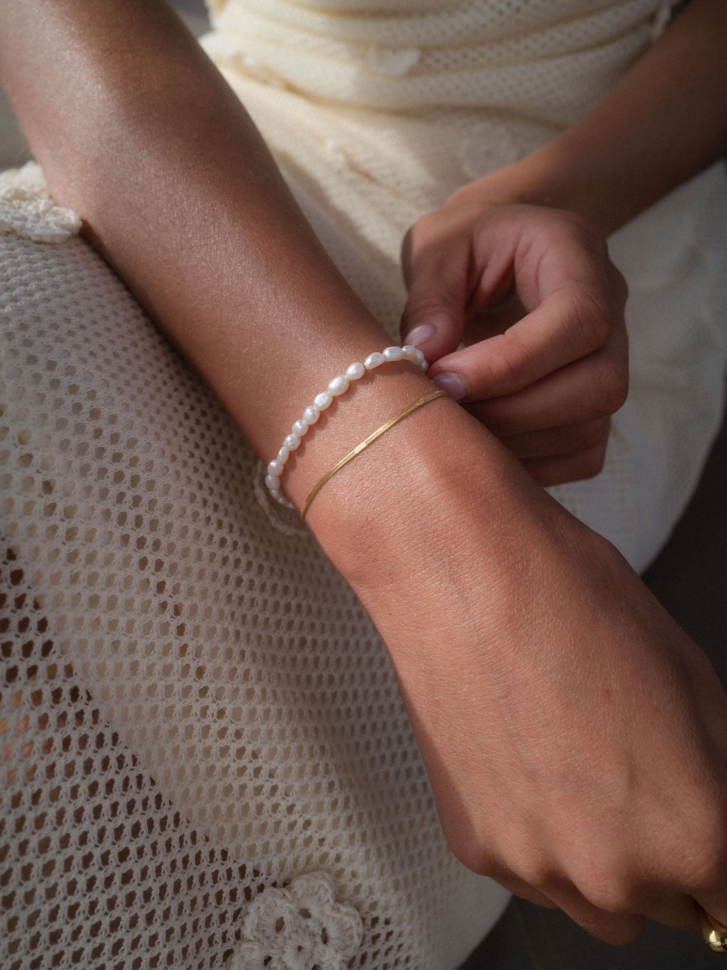 Pearlfection Perlenarmband mit weißen Süßwasserperlen am Handgelenk, elegant und zeitlos von PURELEI.