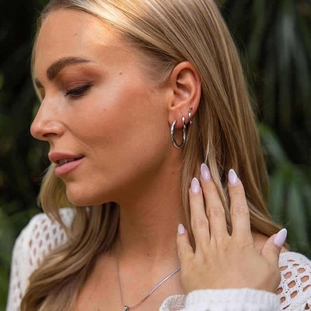 PURELEI Kumu O Creolen aus nickelfreiem, silberfarbenem Edelstahl getragen mit natürlichem, warmem Licht.