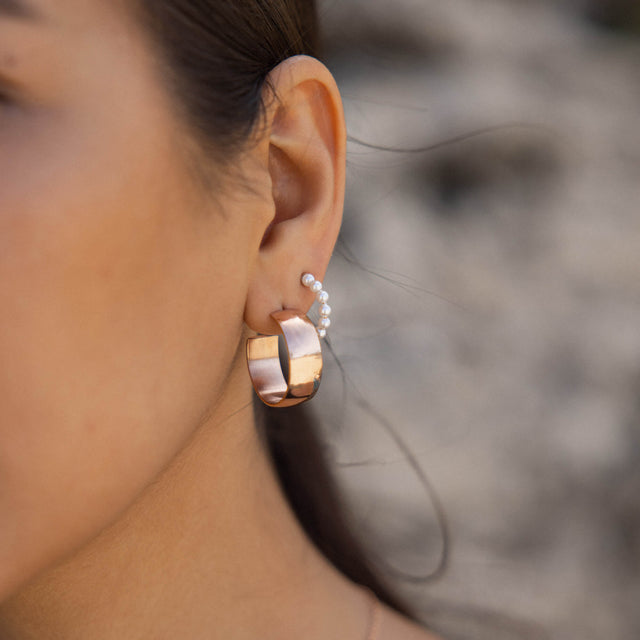 Roségoldene Creolen mit elegantem Design, getragen von PURELEI.