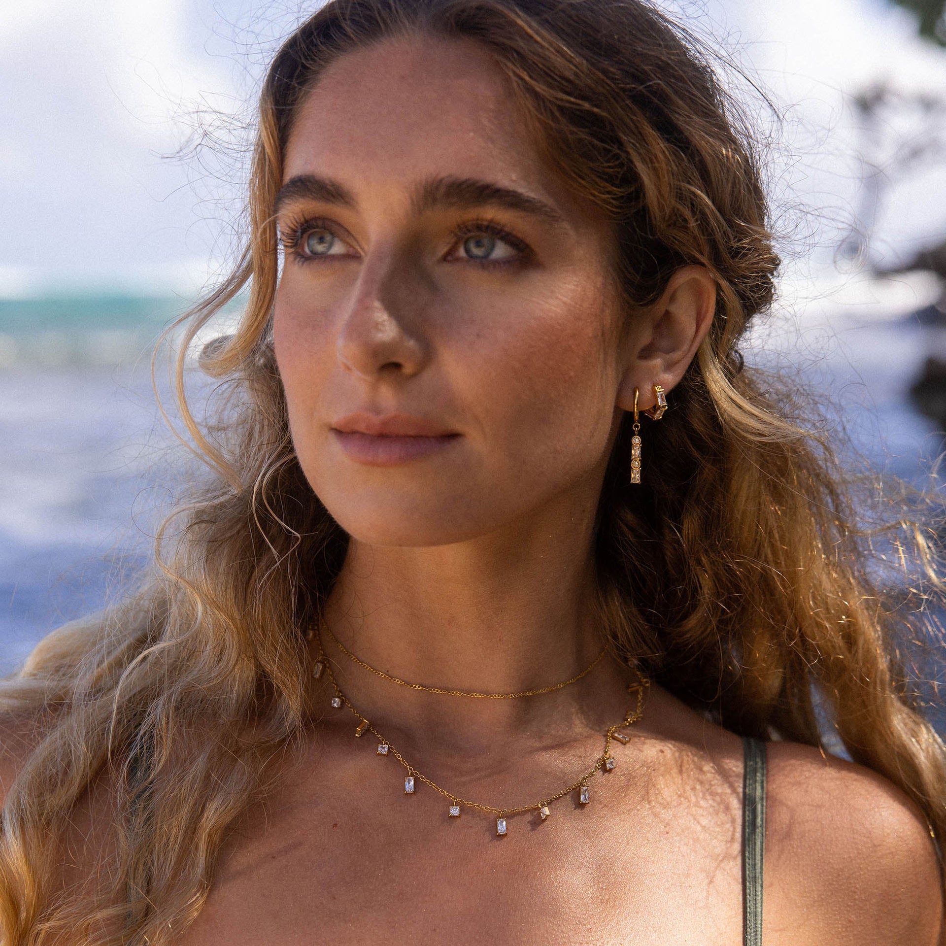 Goldene Kette und Ohrringe mit klaren Steinen, PURELEI, elegant und feminin.