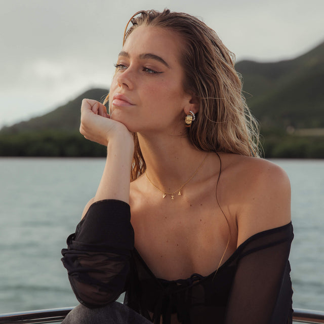 Feine goldene Via Kette von PURELEI, verstellbar, zarter Schriftzug-Anhänger, eleganter Insel-Spirit am Wasser.