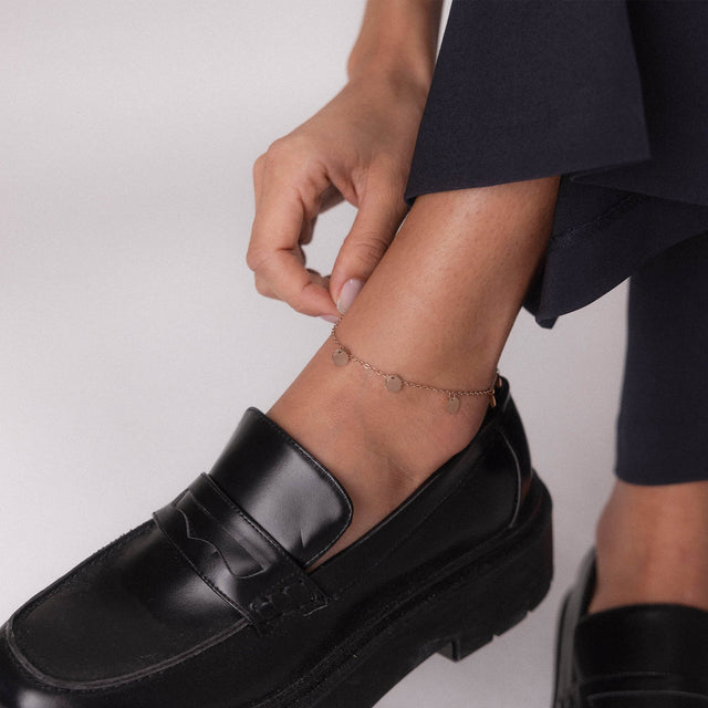 PURELEI Kalea Fusskettchen in Gold mit fünf spiegelnden Anhängern, elegant am Knöchel getragen, feminine Leichtigkeit.