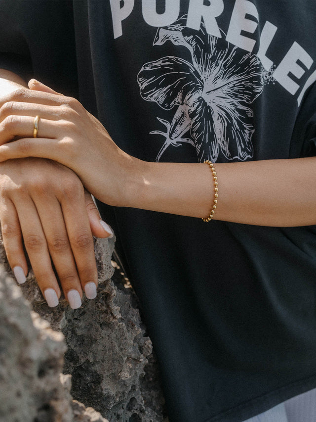 Roségoldenes Armband von PURELEI, zart und elegant, getragen auf einer Hand mit neutralem Nagellack.
