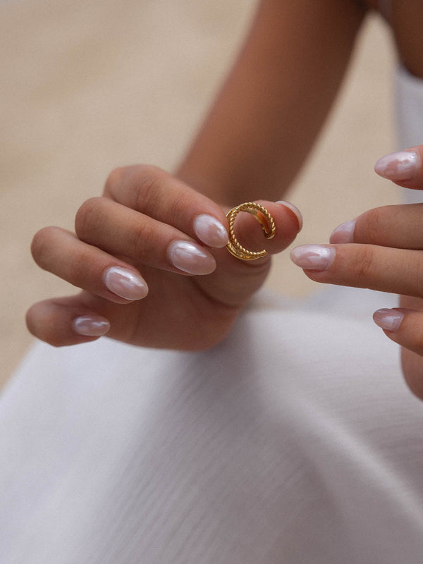 Roségoldenes, gewundenes Ringdesign in zarter Hand, PURELEI inspiriert.