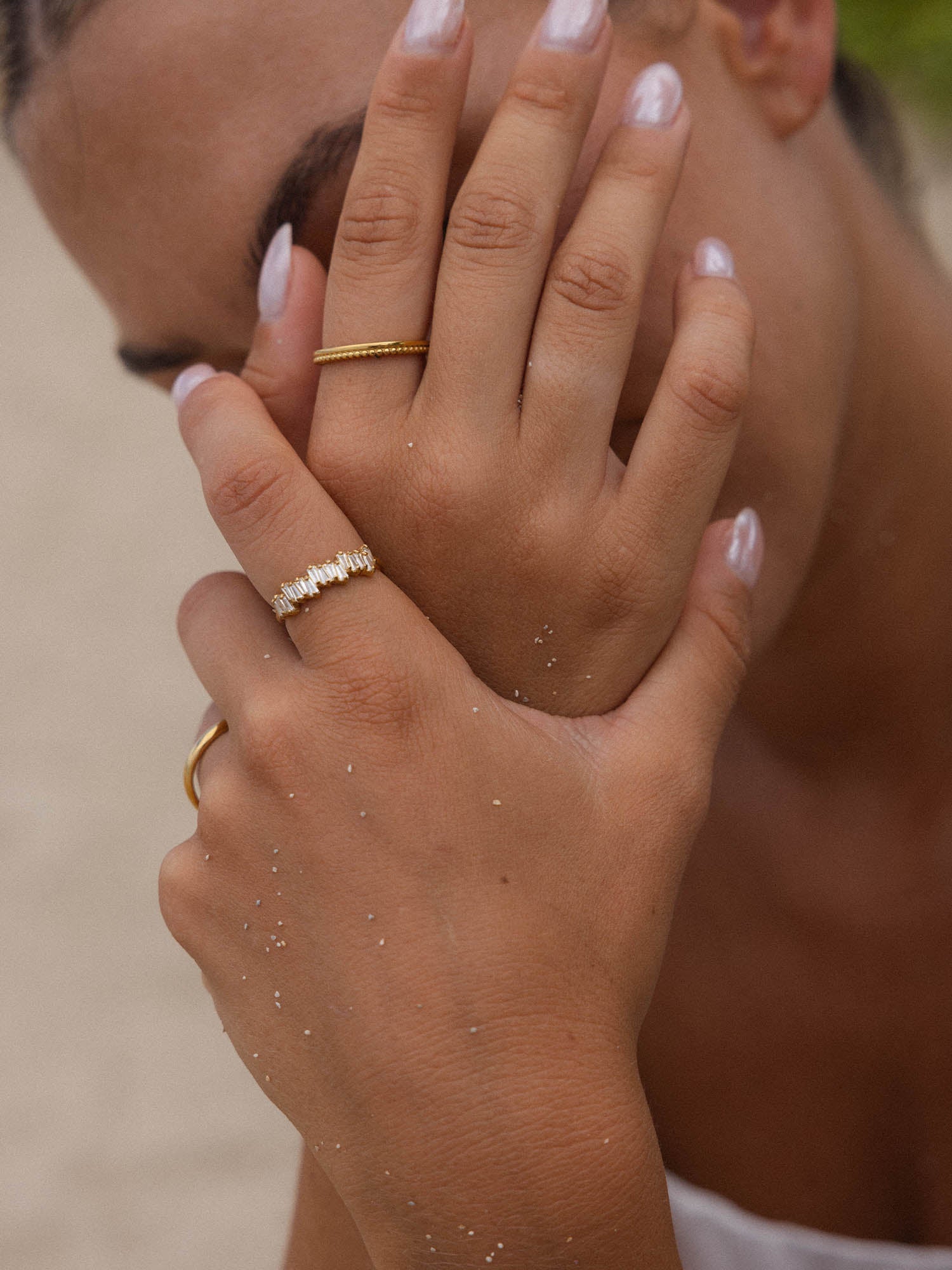 Zarte Ringe aus Roségold, getragen an einer Hand mit sanften Wellen, PURELEI.