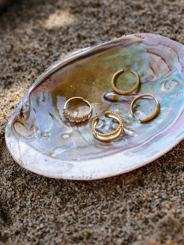Silberne Ringe in Muschel auf Sand, PURELEI inspiriert von der Natur.