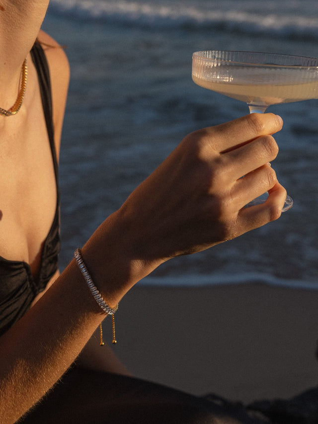 Silbernes Armband mit funkelnden Details, getragen am Strand bei Sonnenuntergang – PURELEI.