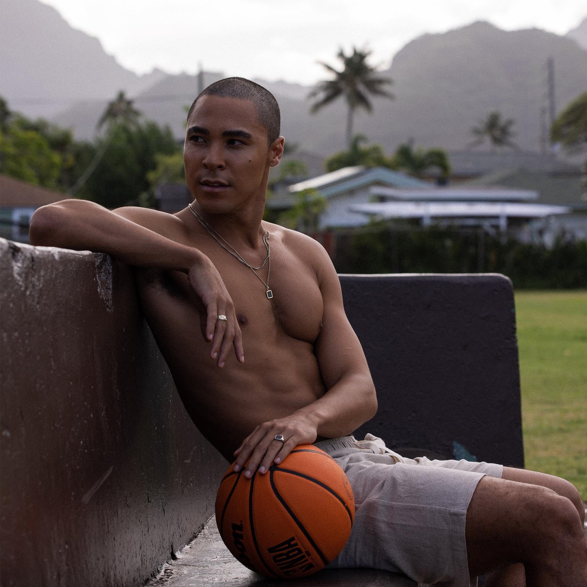 Mann mit Basketball, tragend PURELEI Schmuck, entspannte Stimmung im Freien.