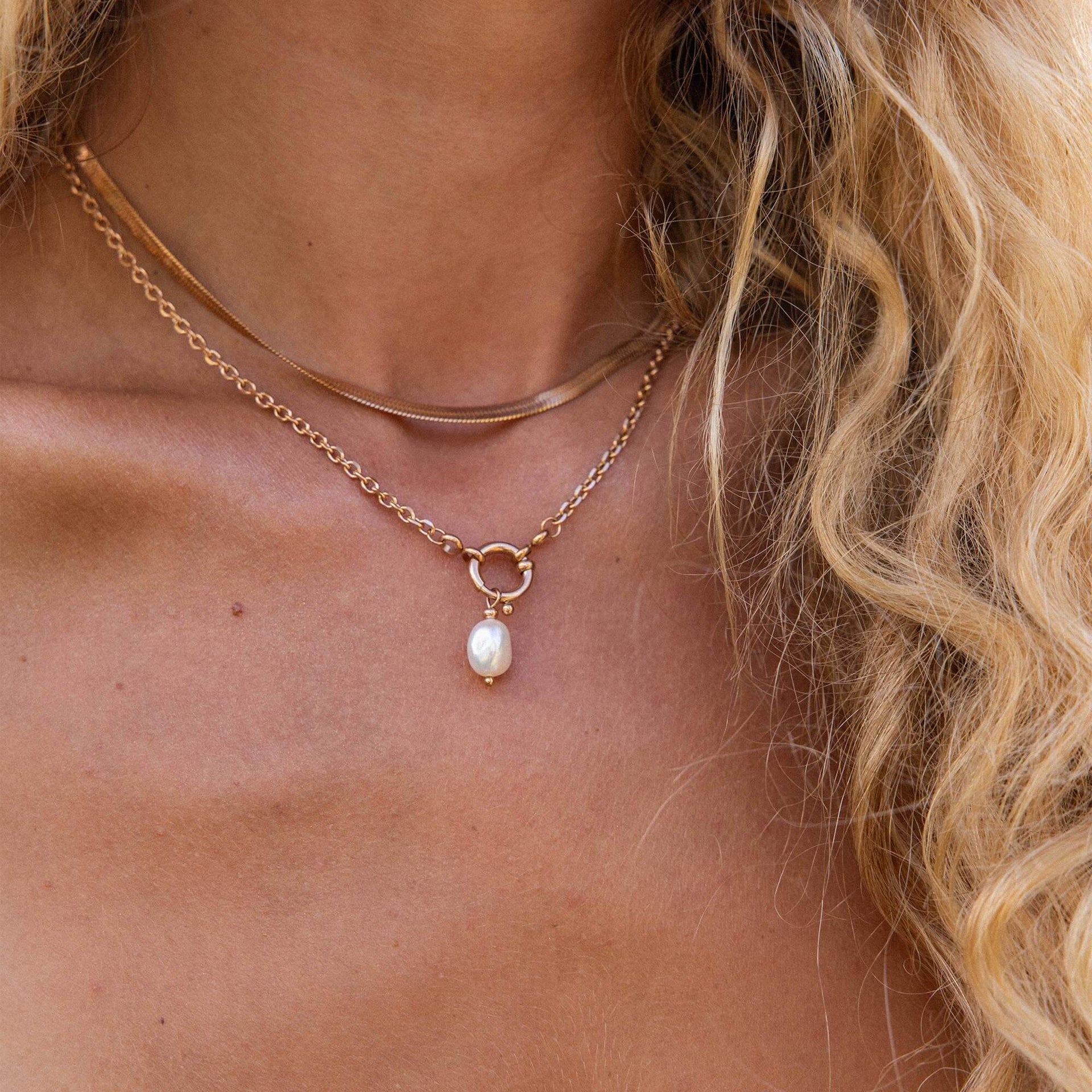 Zwei goldene Ketten mit ovalem Anhänger, getragen mit natürlichem Glow – PURELEI.