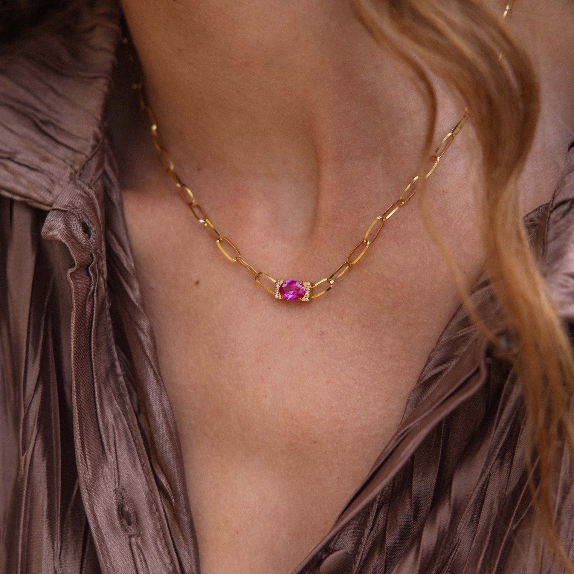 Goldene Kette mit einzigartigem Anhänger, getragen auf einer eleganten Bluse von PURELEI.