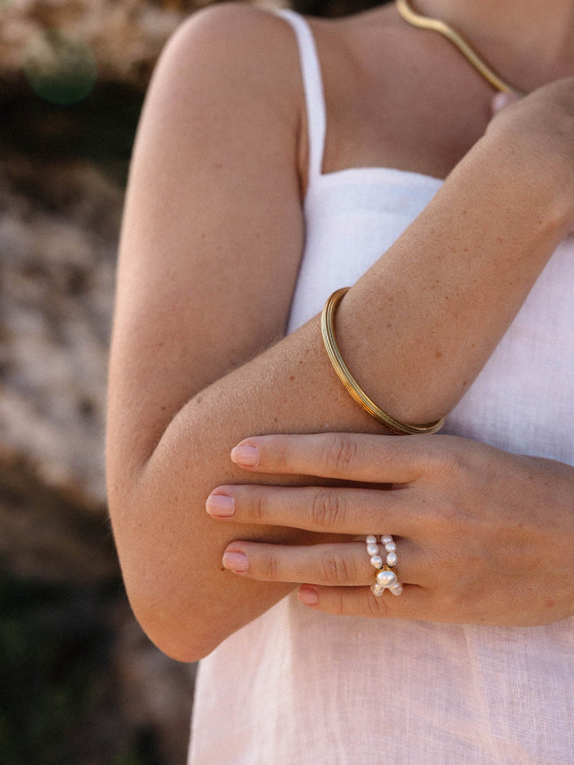 Roségoldenes Armband und Perlenring von PURELEI, elegant und feminin, in natürlicher Umgebung.
