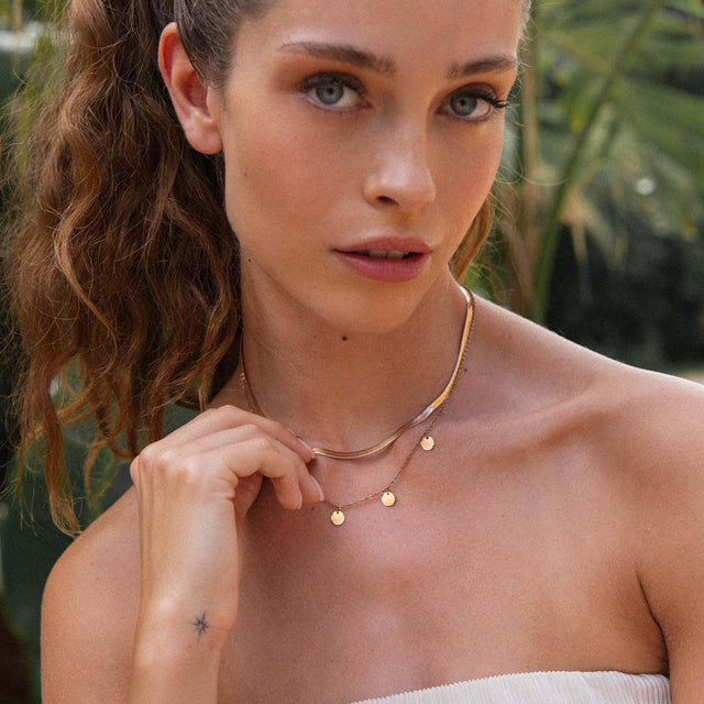 Zarte roségoldene Kette mit Anhängern, getragen in tropischer Umgebung – PURELEI.