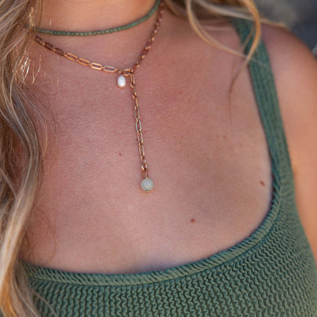 PURELEI Aventurine Charm in goldener Kette mit grünem Aventurin und Perle, elegant und feminin getragen.