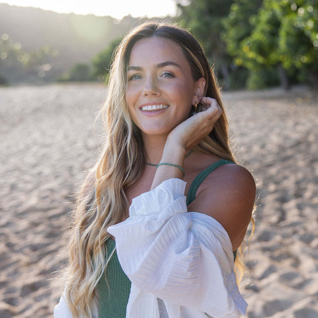 Aventurine Kette von PURELEI in Gold mit zarten Perlen, sommerlich am Strand getragen, natürlich und elegant.