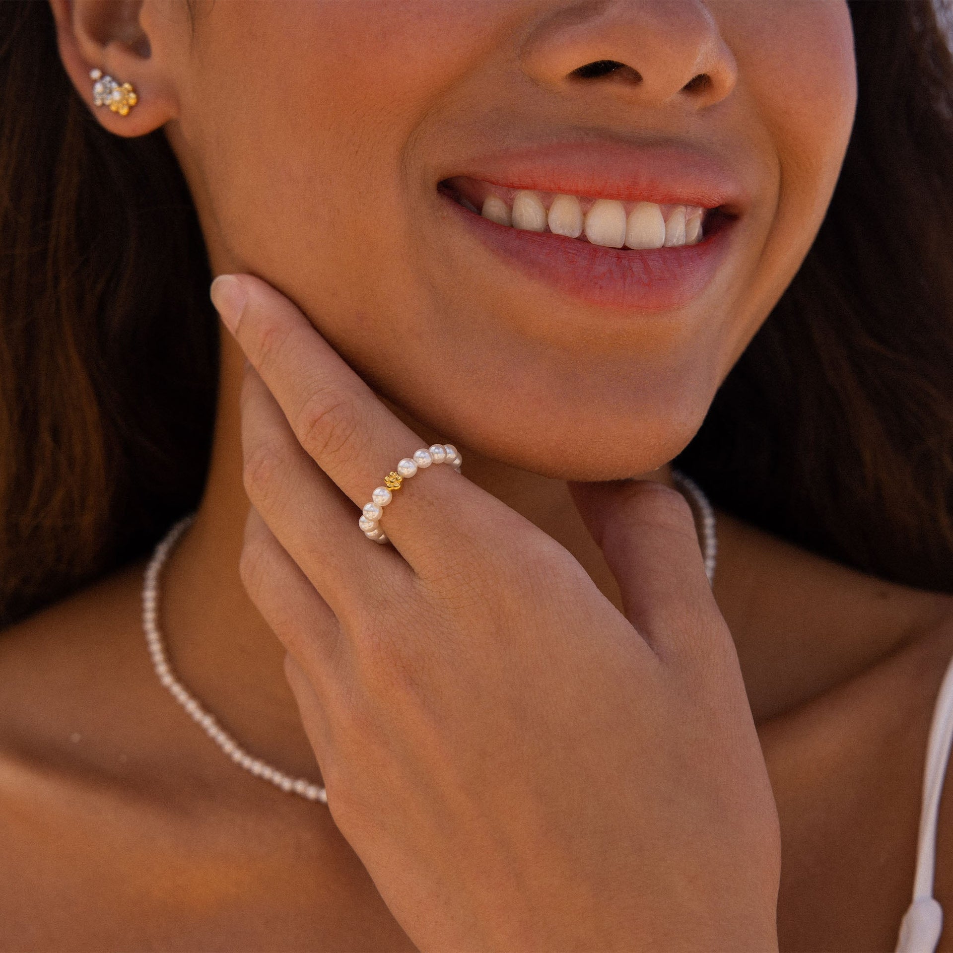 Elasticer PURELEI Anxiety Shiny Bloom Ring aus schimmernden Perlen mit zarter Blüte, feminin und elegant getragen.